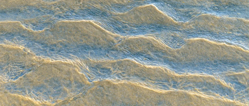 Shallow clear ocean water rippling over sandy seafloor