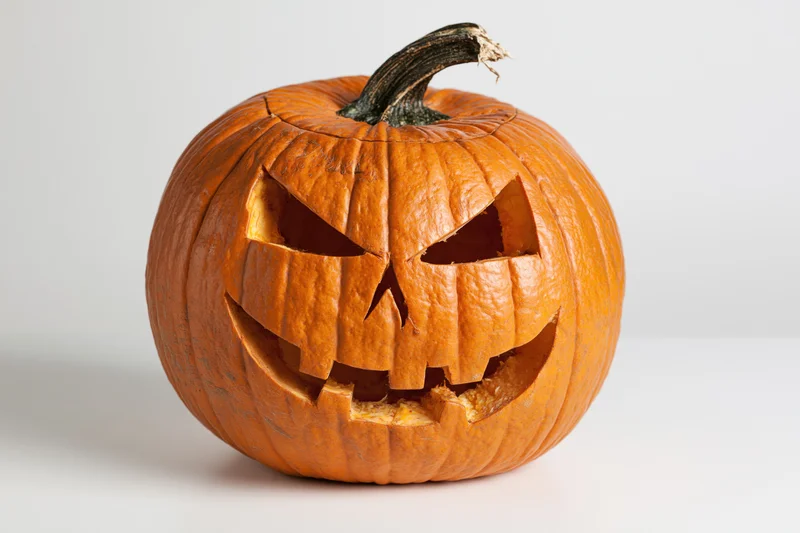 Carved pumpkin with angular face on white background