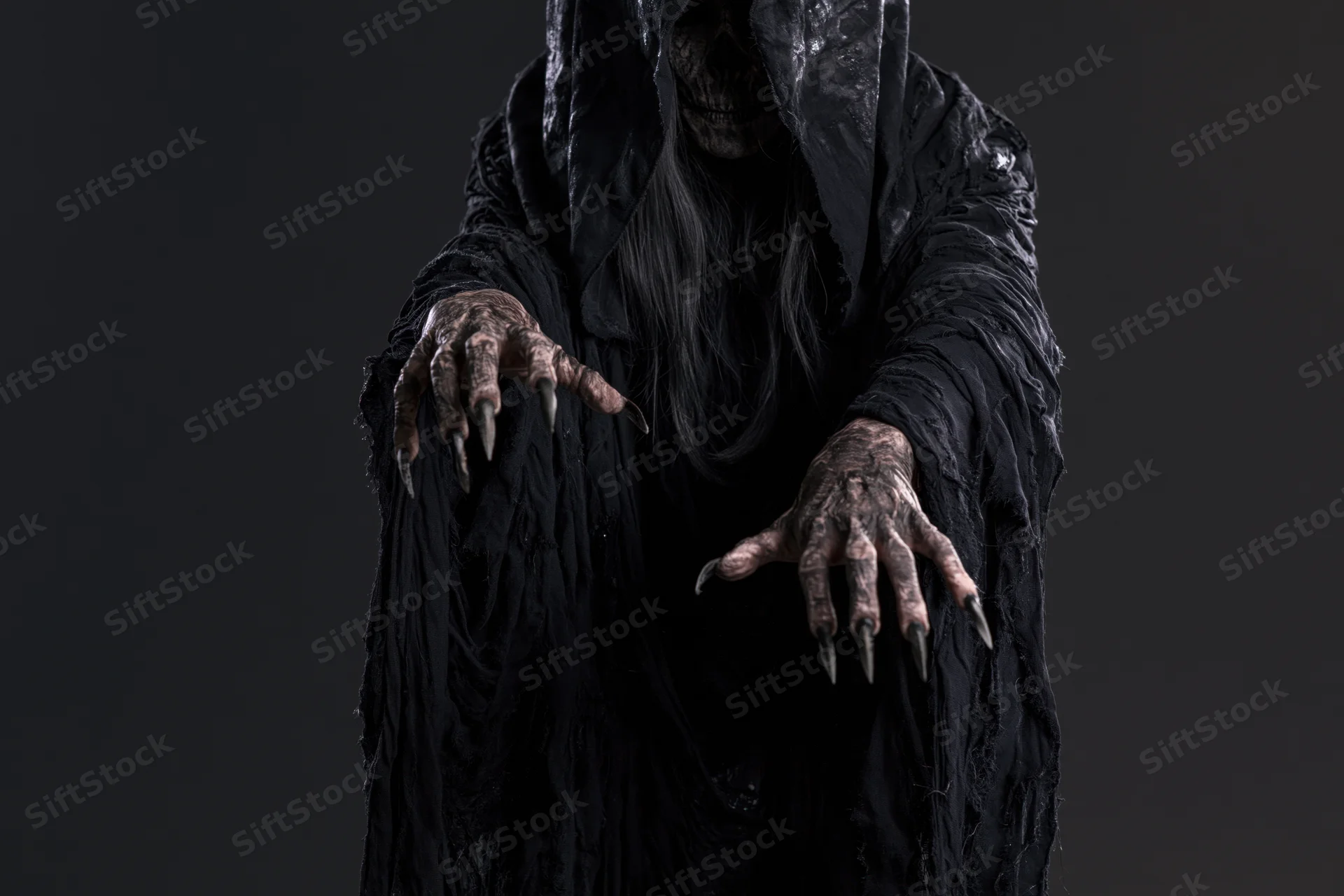 Hooded wraith figure with clawed hands reaching forward against dark background
