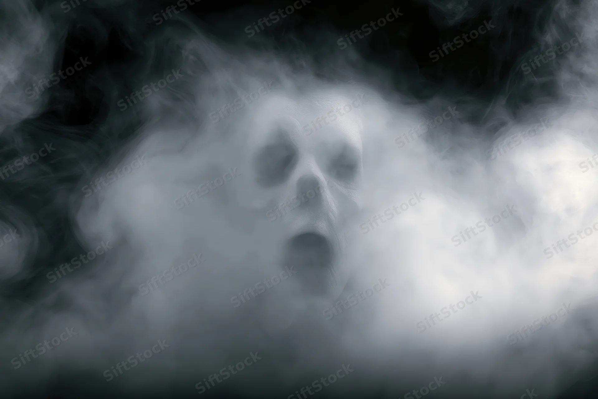 Ghostly face emerging from swirling smoke and fog