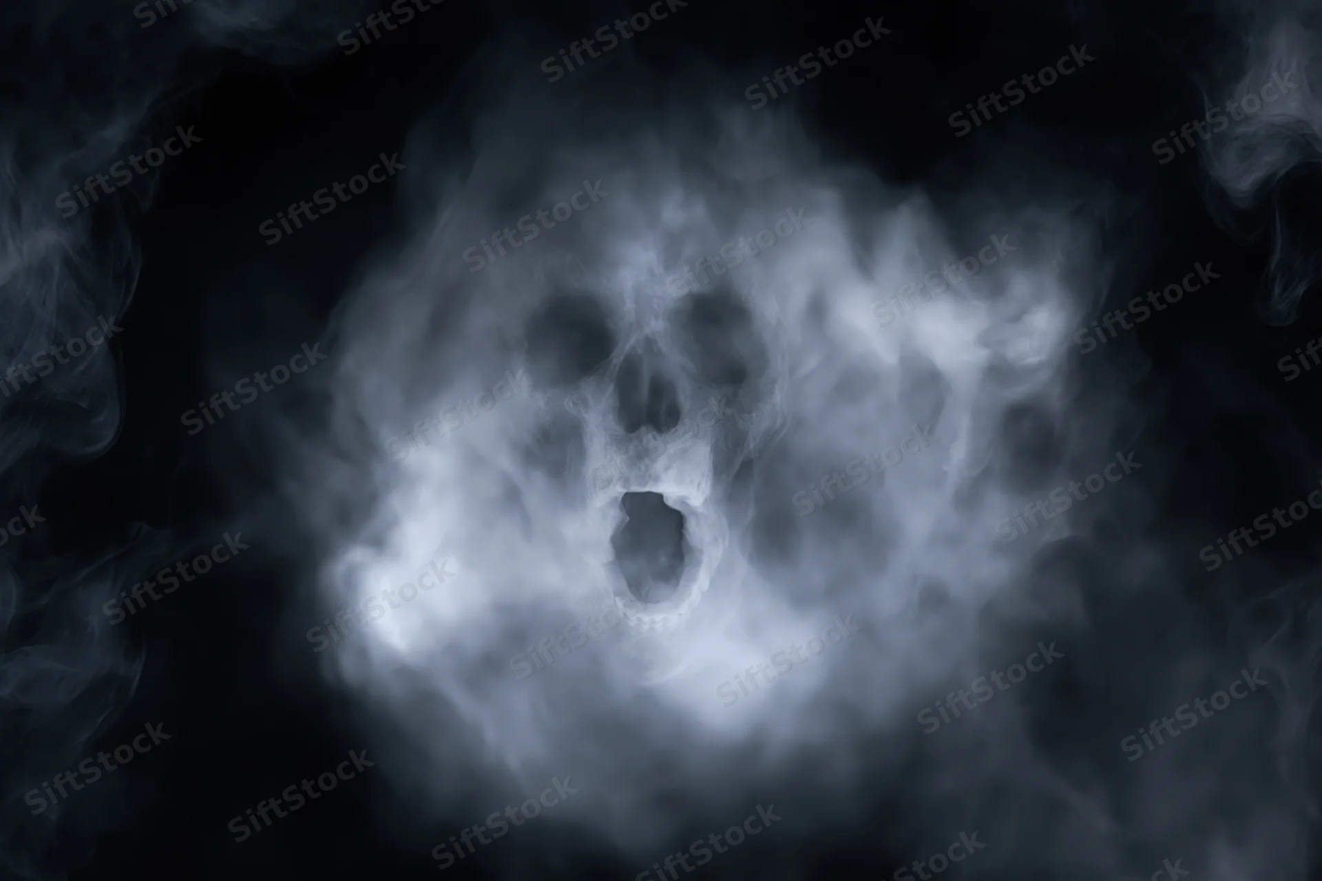 Ghostly skull face emerging from swirling smoke and fog in dark atmosphere