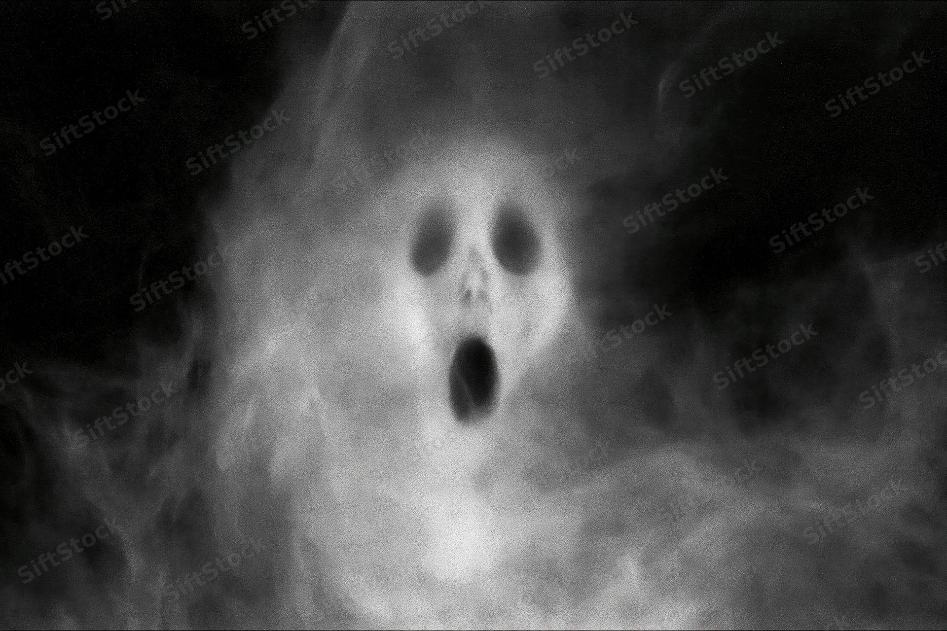 Ghostly face screaming in swirling smoke against dark background
