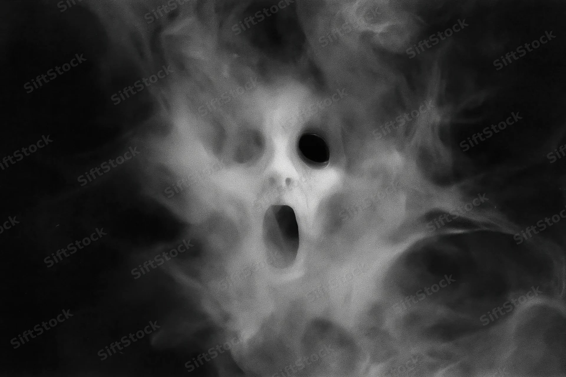 Ghostly face screaming in swirling smoke against dark background
