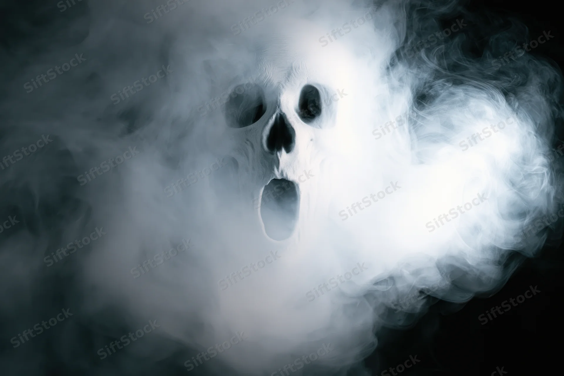 Ghostly skull screaming in swirling white smoke against black background