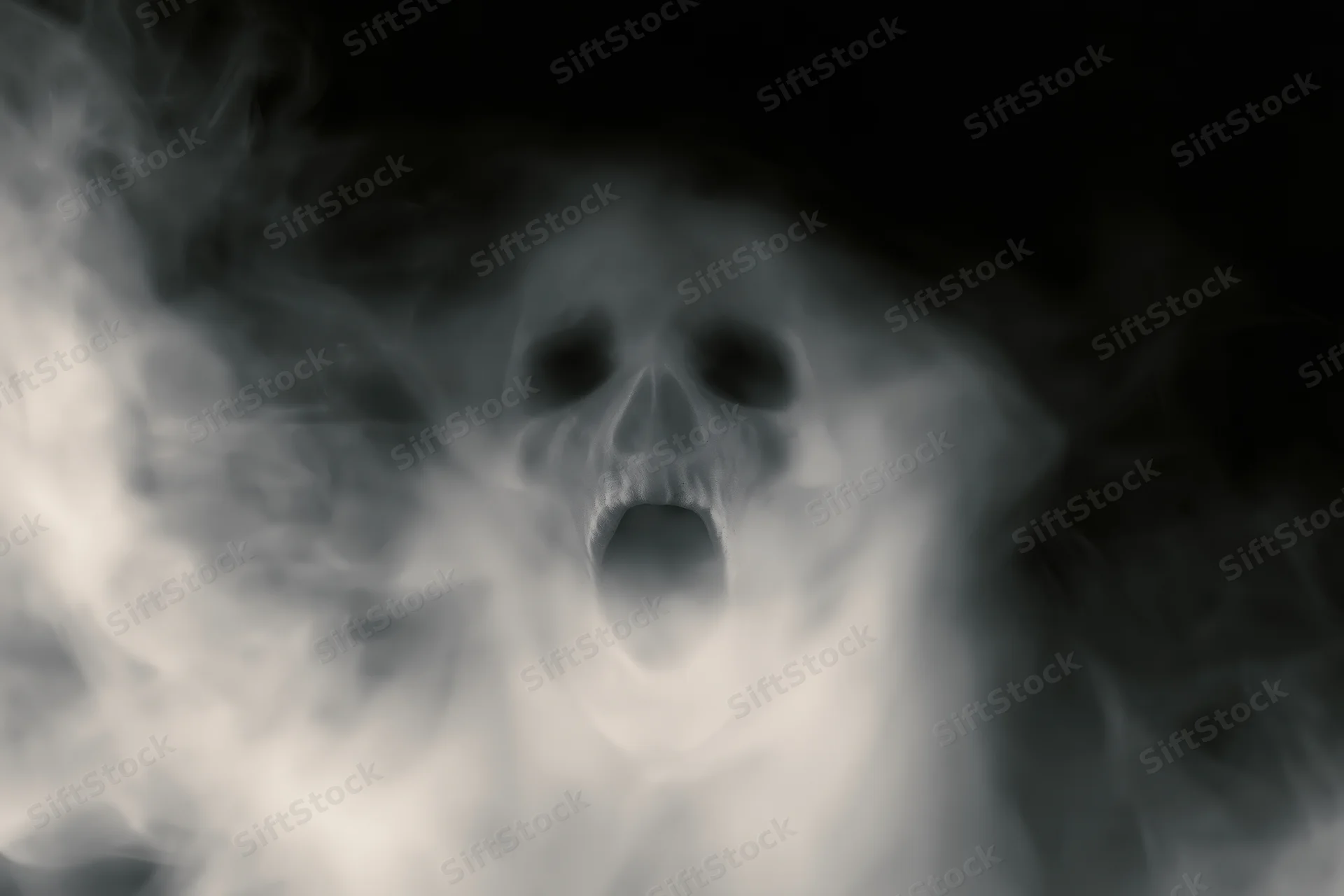 Ghostly skull screaming through swirling white smoke in darkness