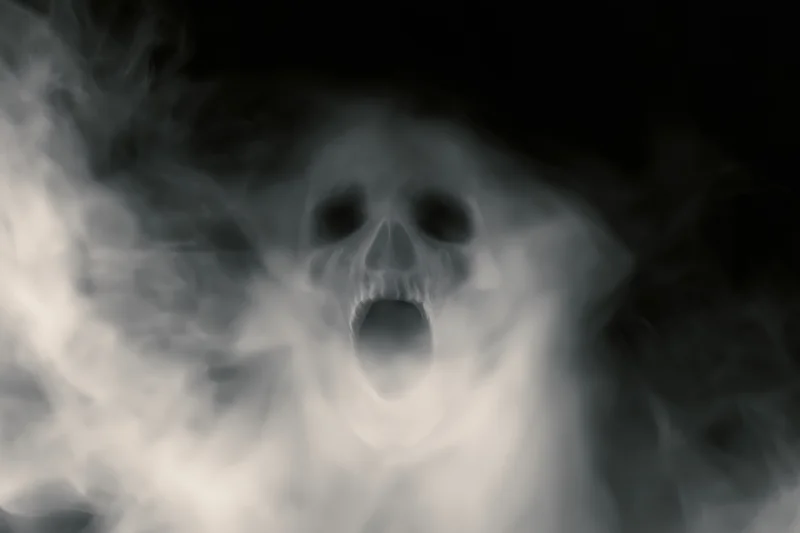 Ghostly skull screaming through swirling white smoke in darkness