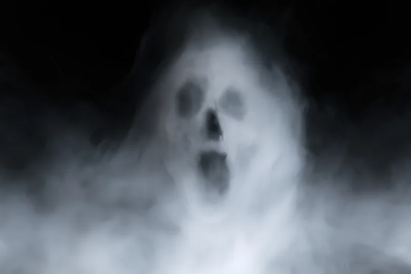 Ghostly screaming face emerging from swirling white smoke in dark atmosphere
