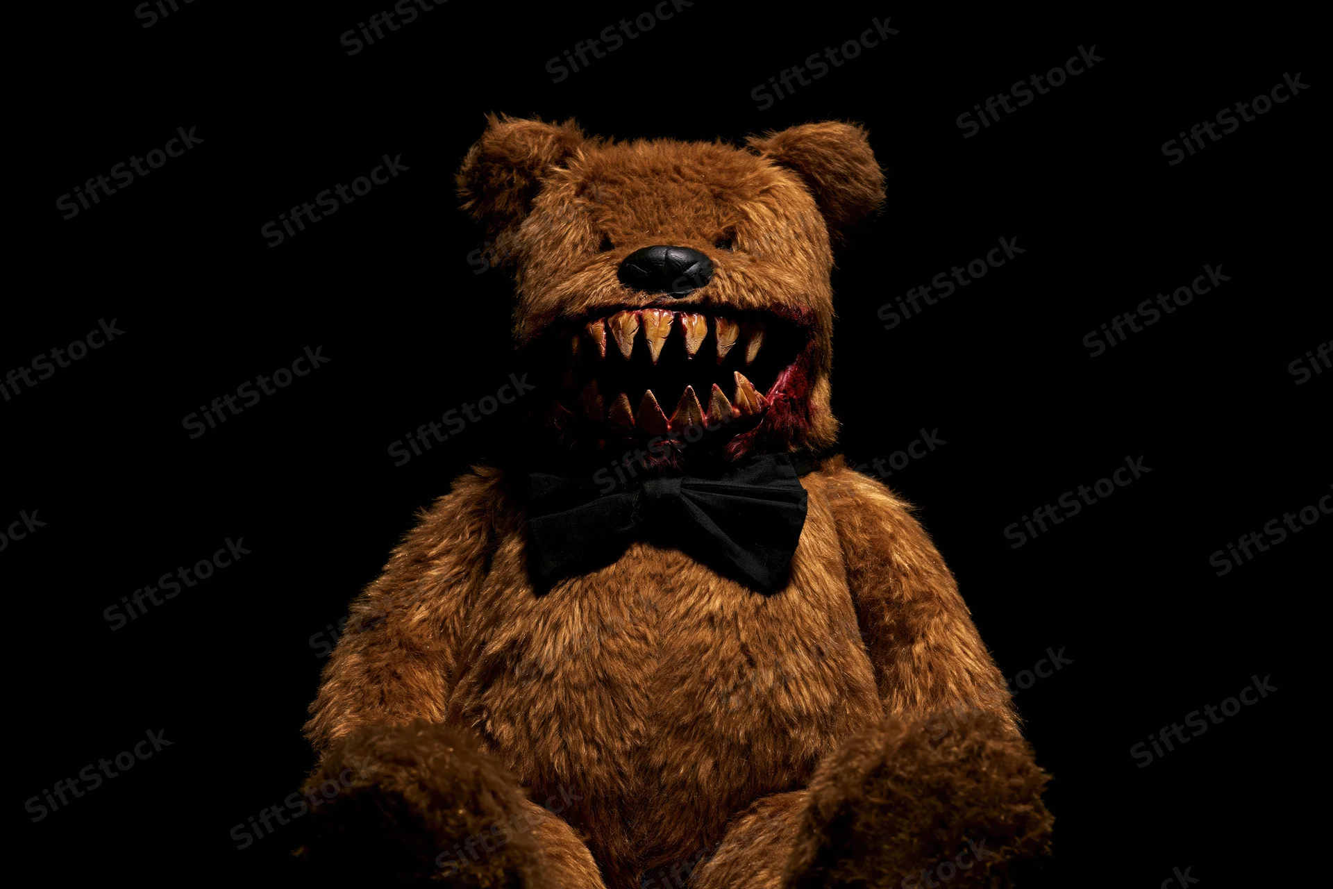 Horror-themed teddy bear with jagged teeth and blood on black background