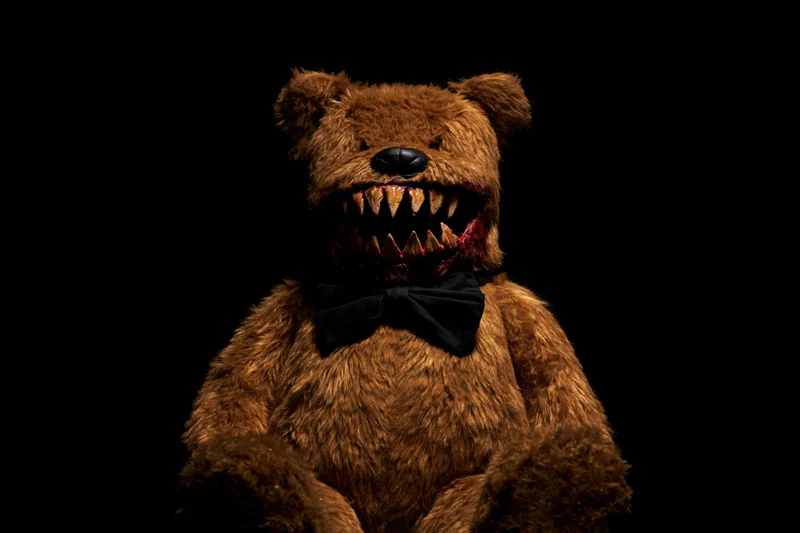 Horror-themed teddy bear with jagged teeth and blood on black background