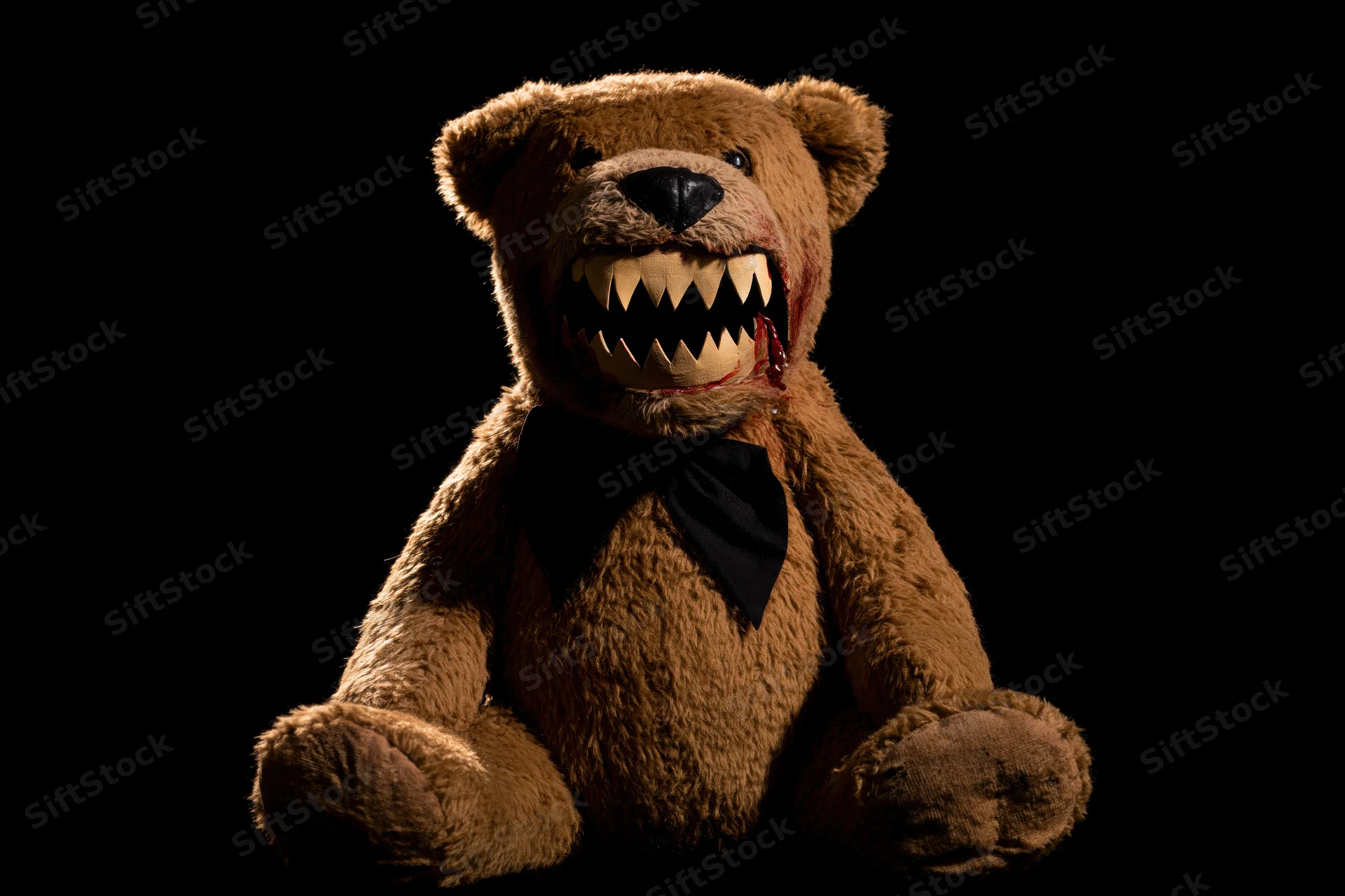 Horror-themed teddy bear with jagged teeth and blood on black background