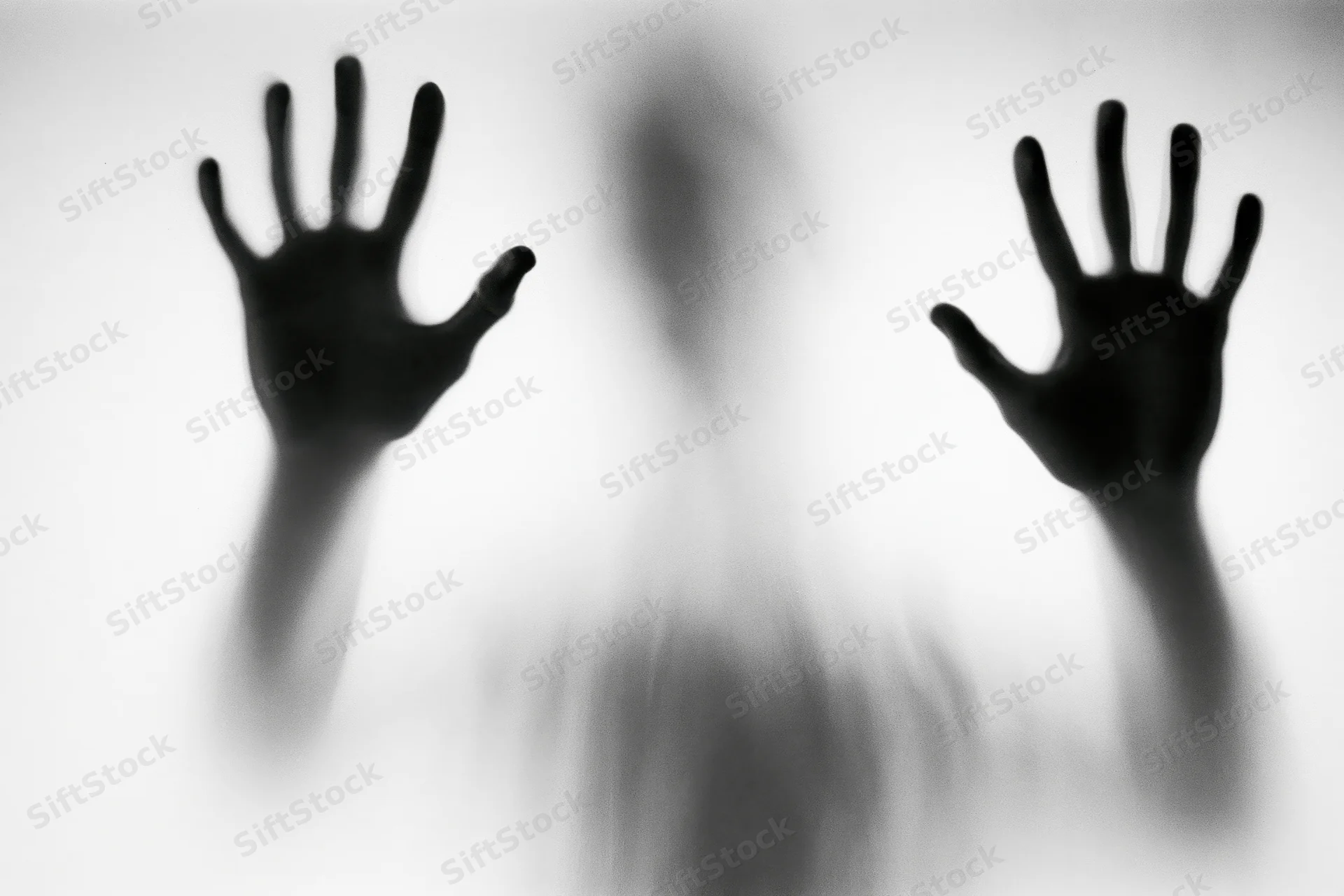 Silhouette of a person pressing hands against frosted glass