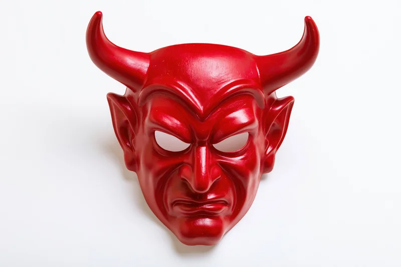 Red devil mask with curved horns and menacing expression on white background