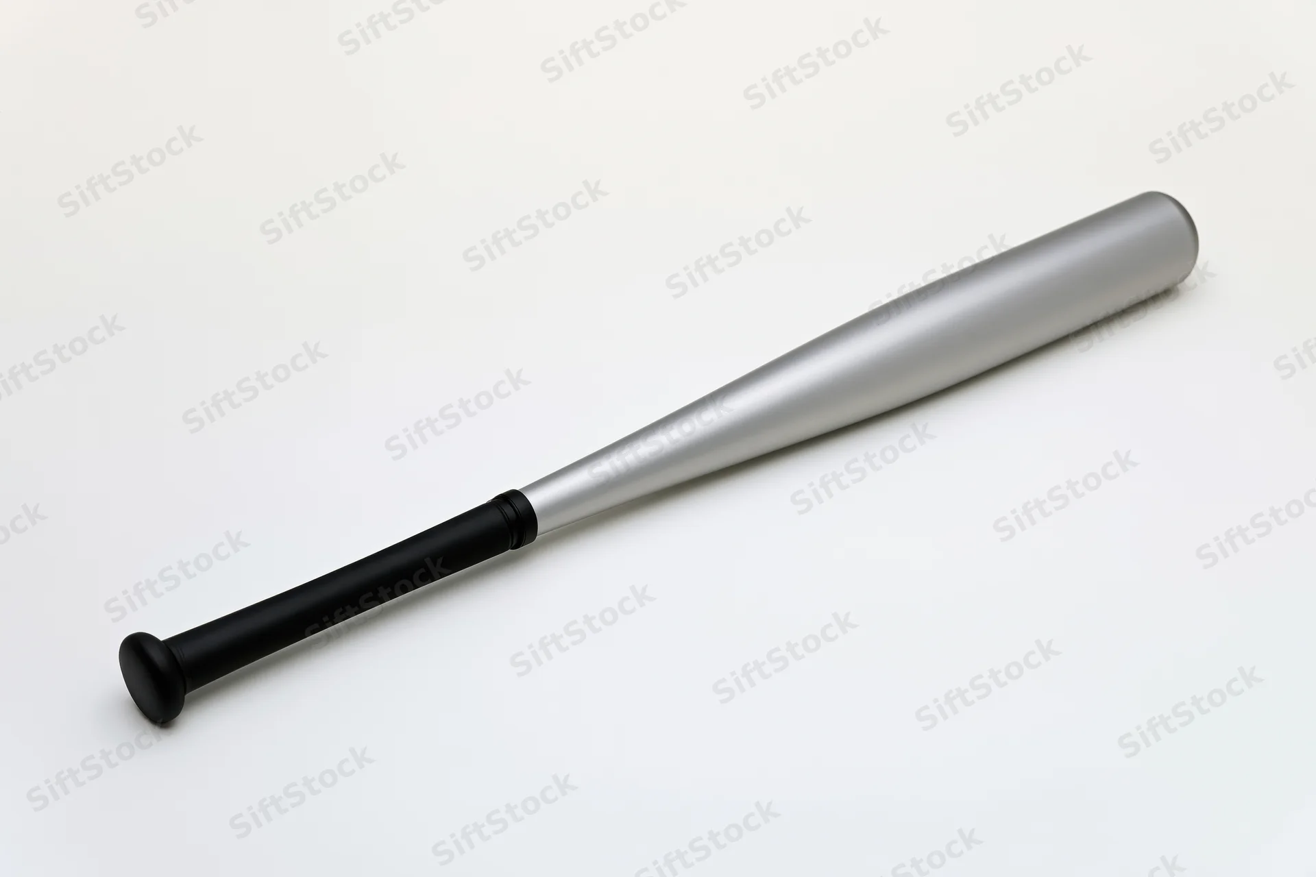 Aluminum baseball bat lying diagonally on white background