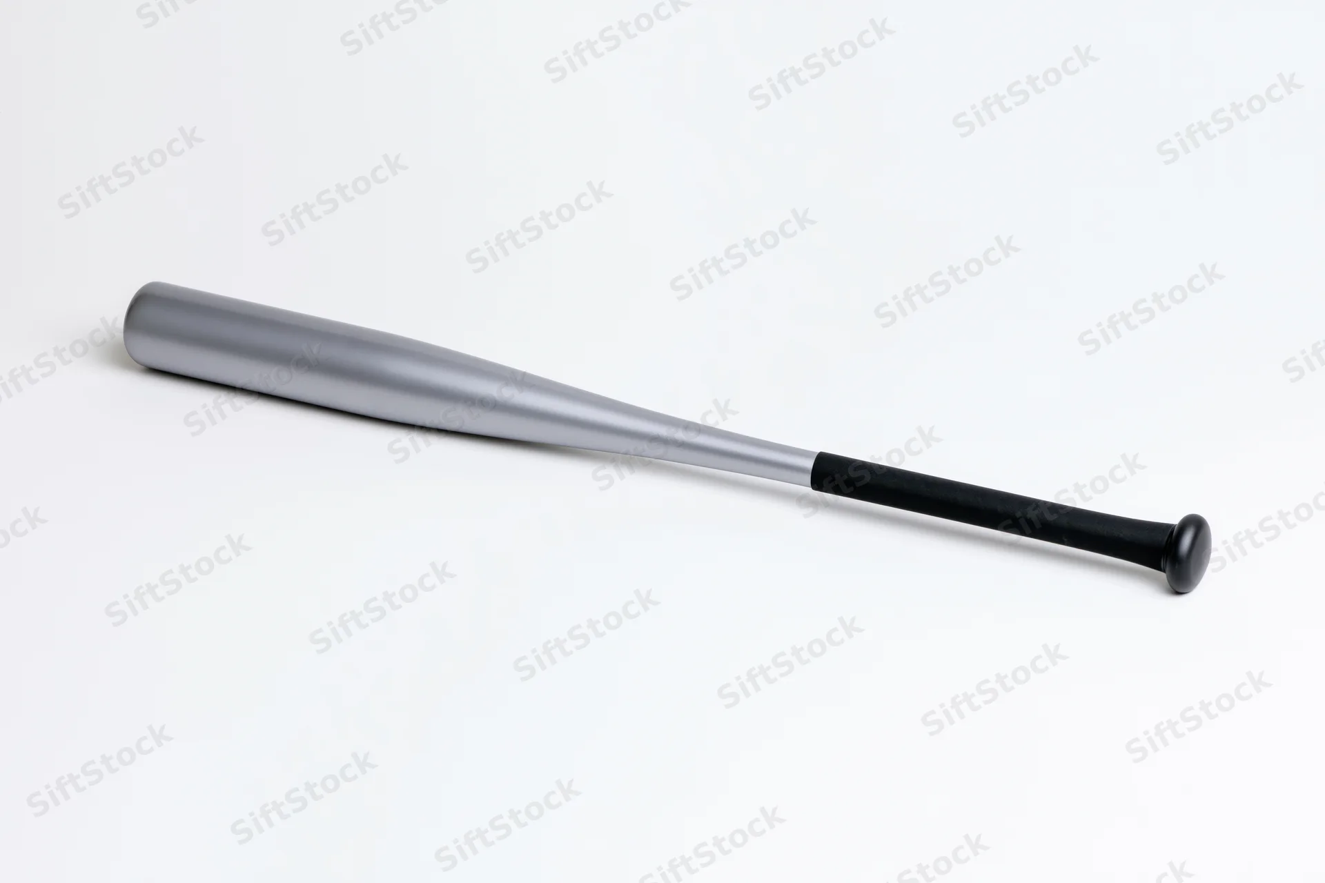 Aluminum baseball bat lying diagonally on white background