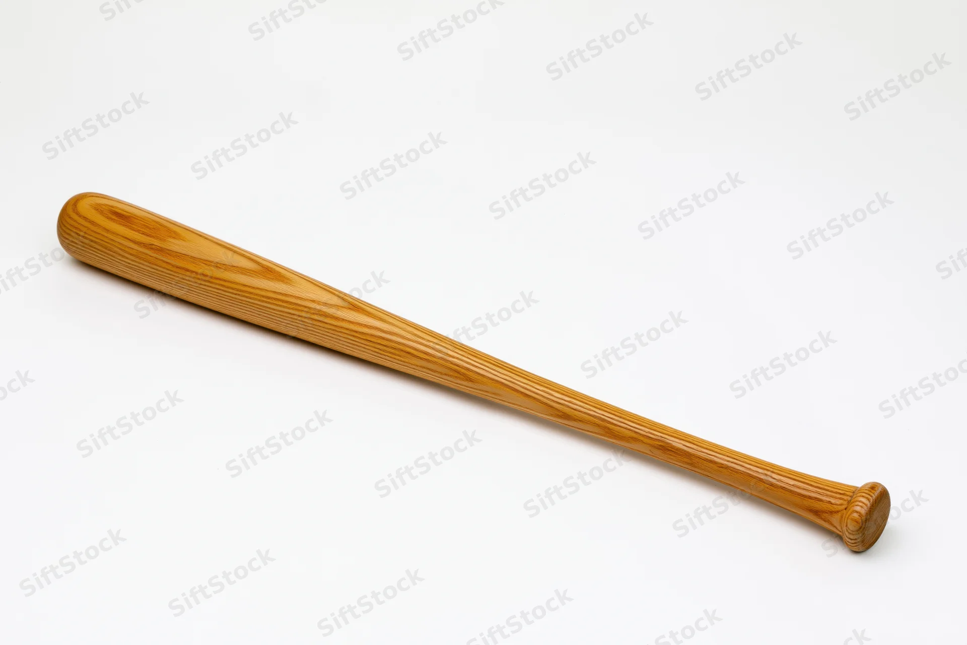 Wooden baseball bat lying diagonally on plain white studio background