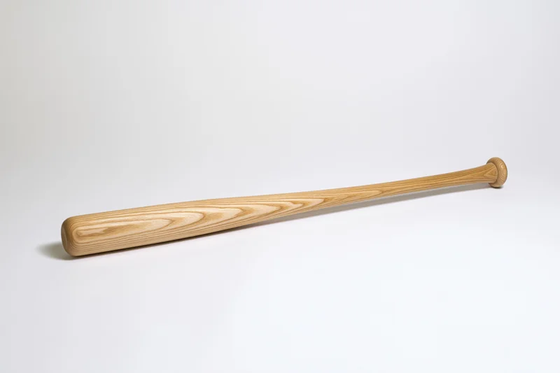 Wooden baseball bat resting diagonally on a plain white surface