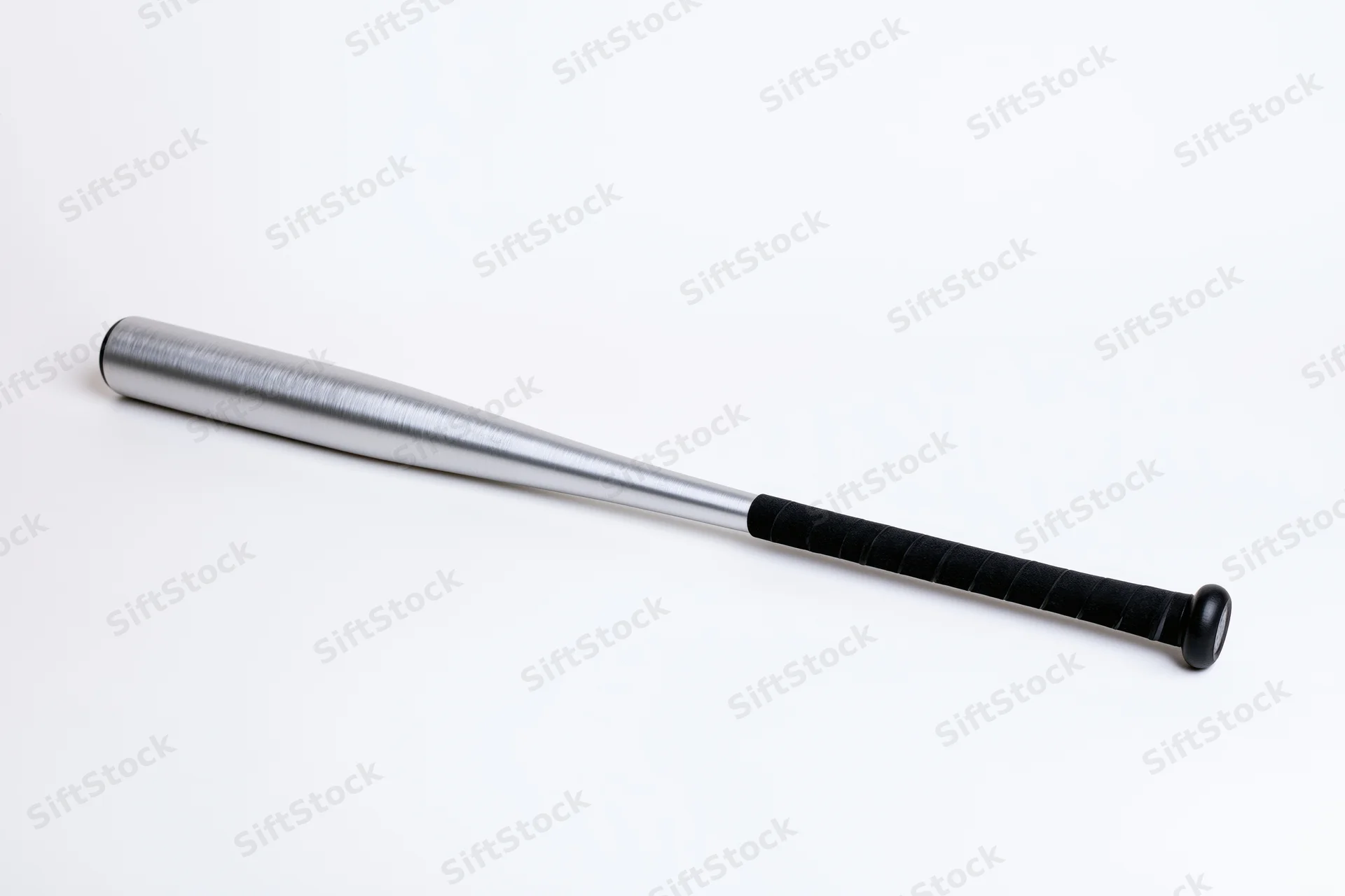 Aluminum baseball bat lying diagonally on white background