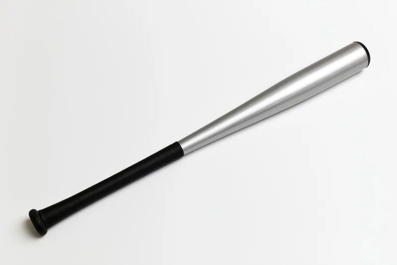 Aluminum baseball bat lying diagonally on plain white surface