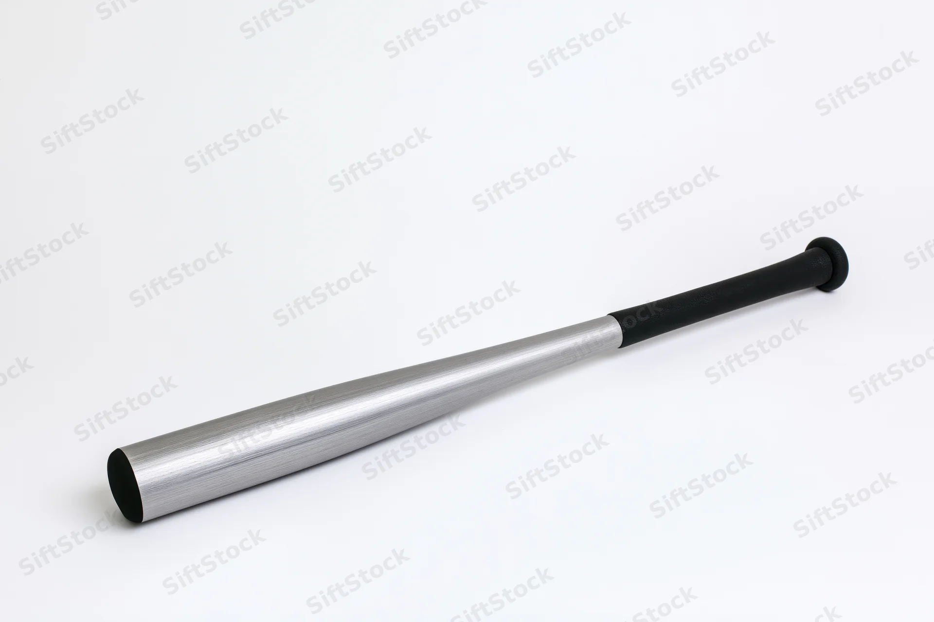 Aluminum baseball bat lying diagonally on white surface