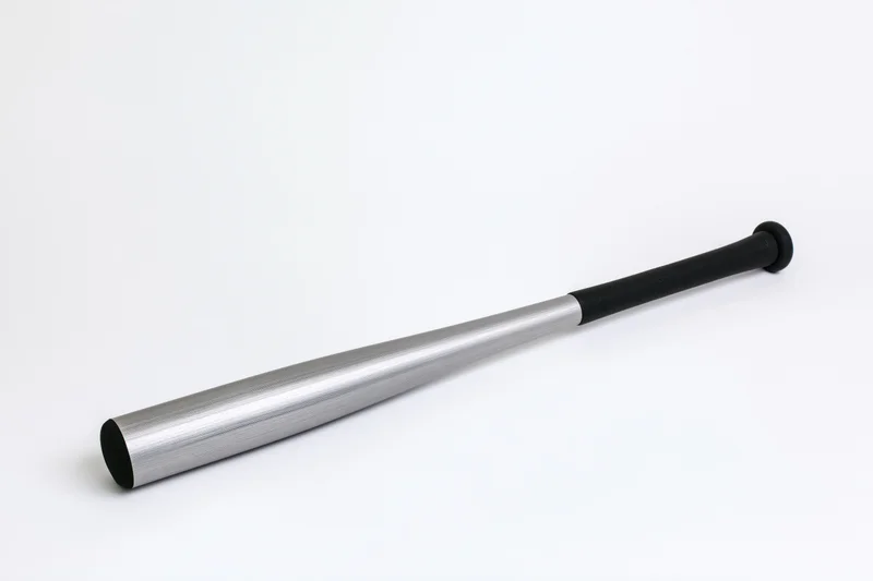 Aluminum baseball bat lying diagonally on white surface