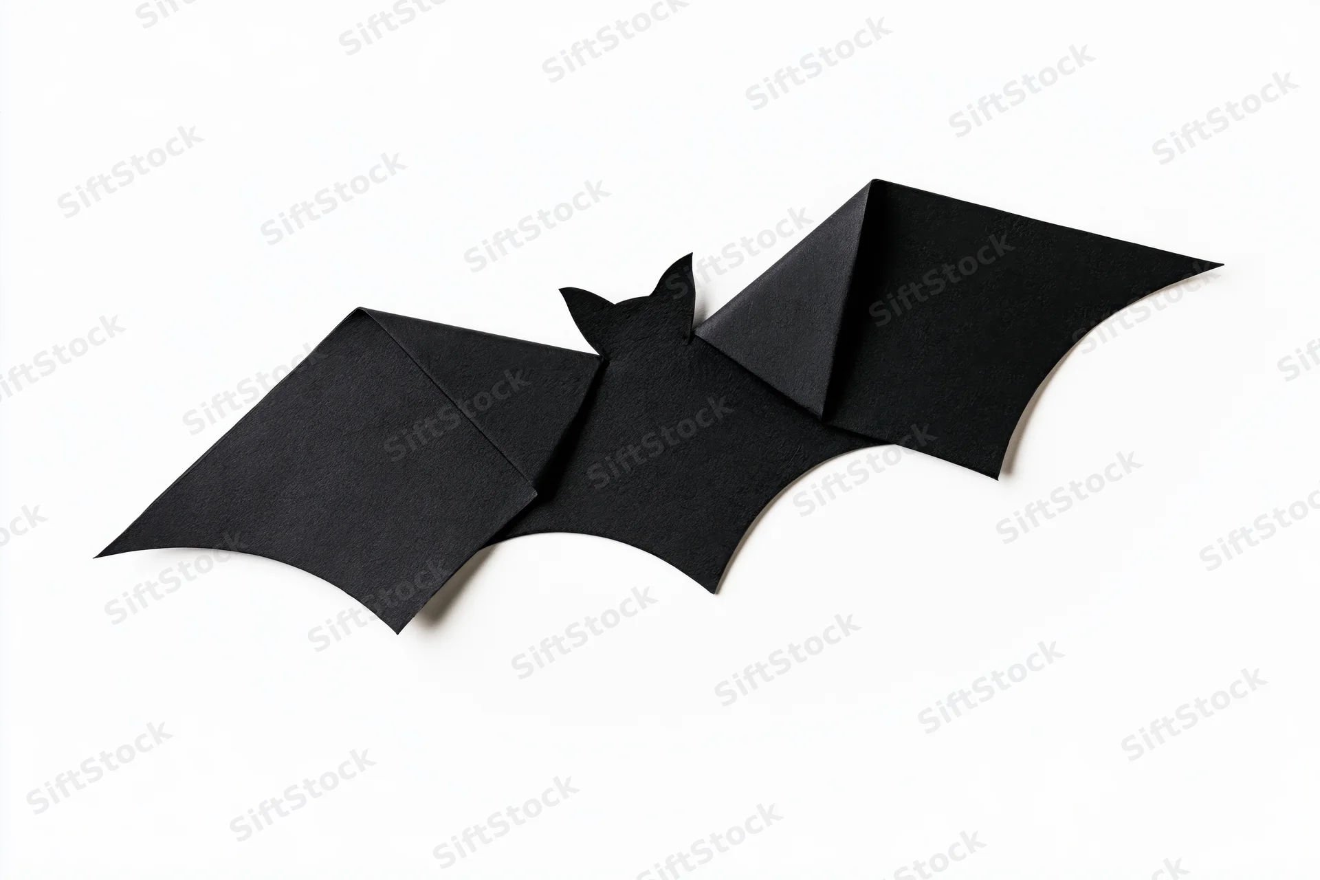 Black origami bat with folded wings isolated on white background