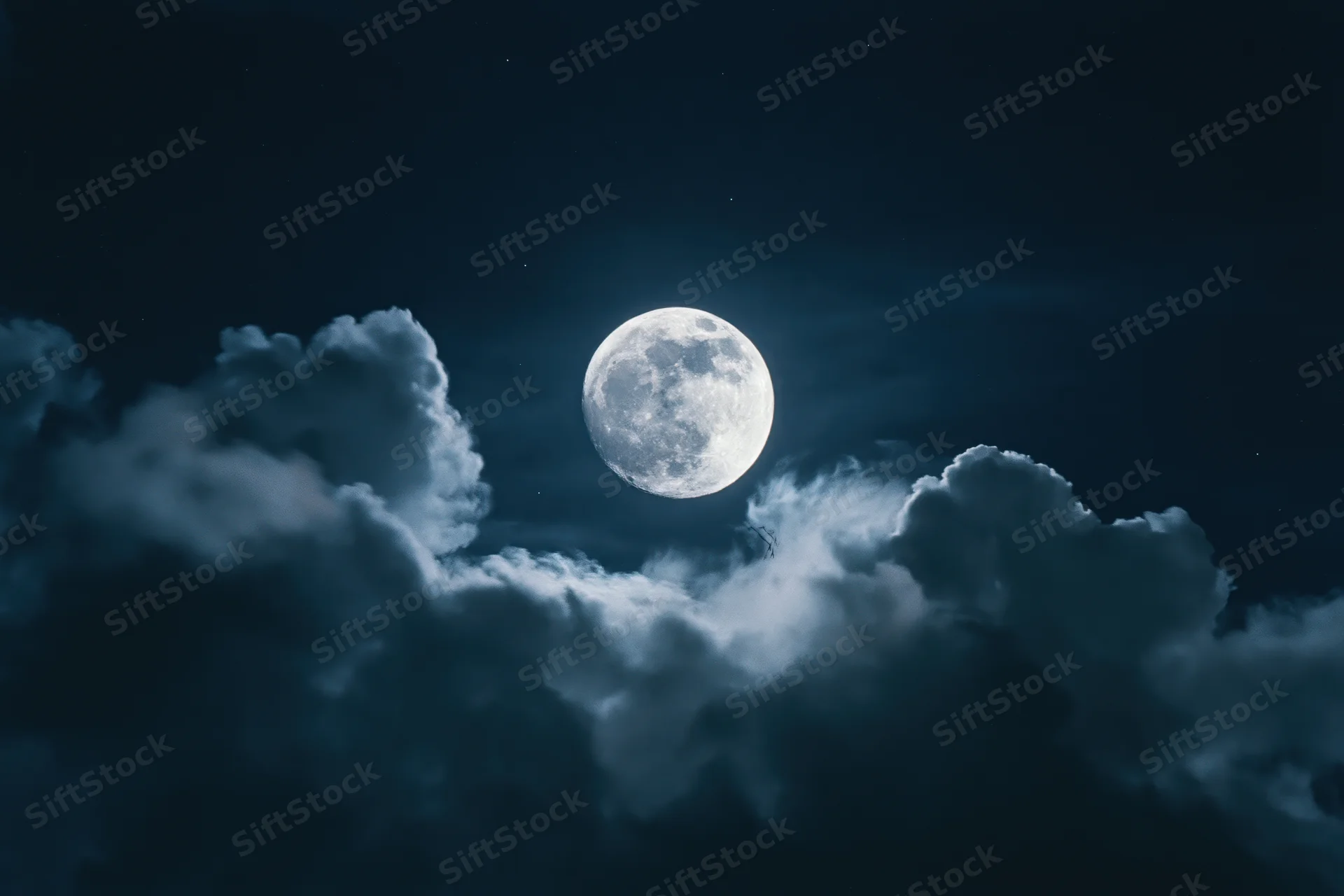 Full moon glowing in dark night sky surrounded by billowing clouds