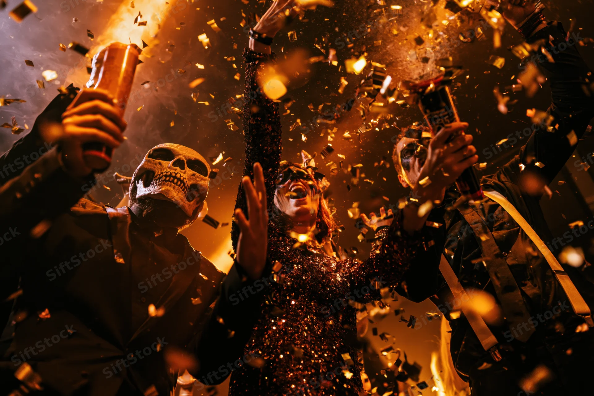Costumed partygoers celebrating with beer and confetti indoors