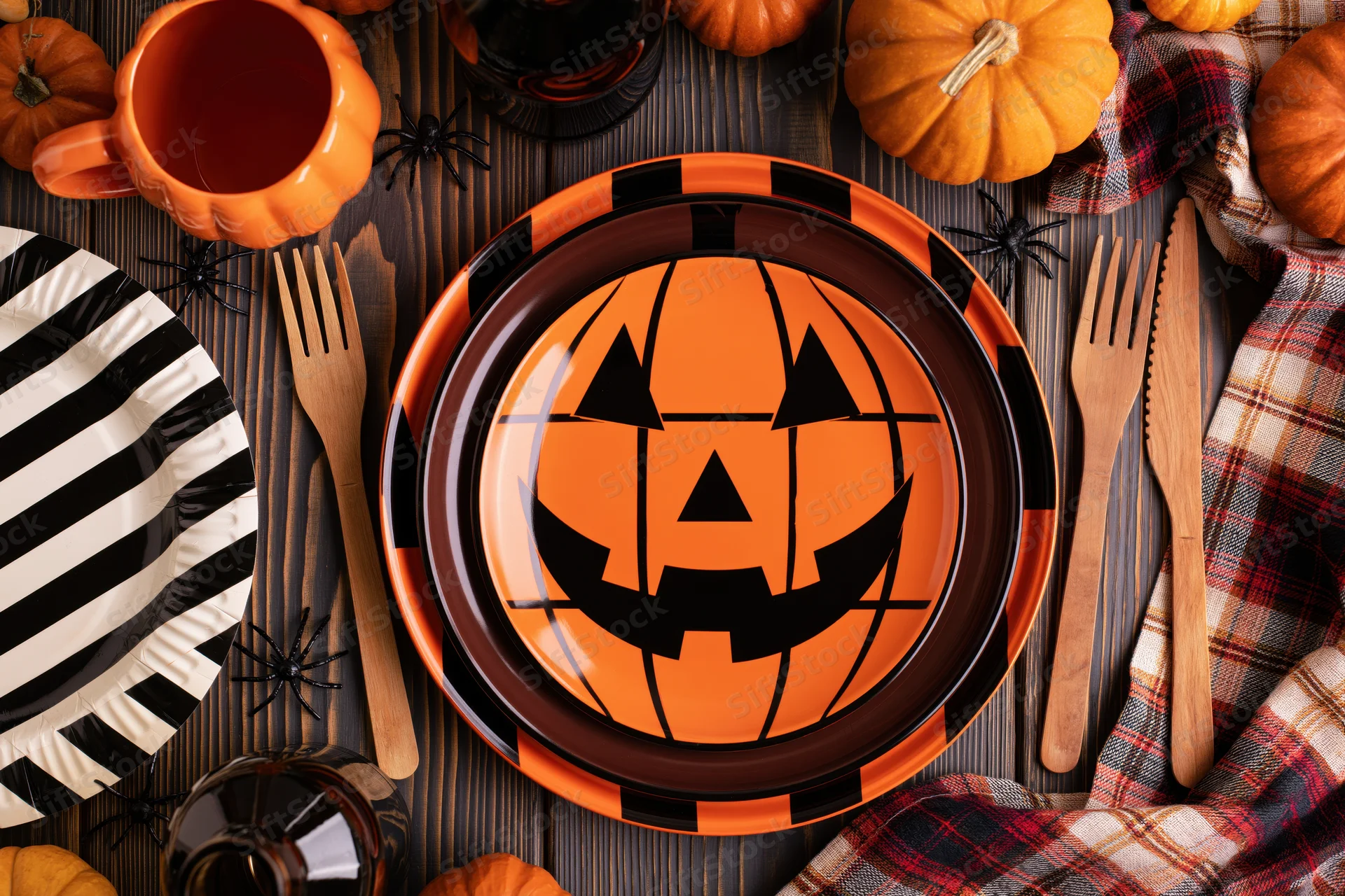 Halloween table setting with jack-o-lantern plate and pumpkin decor overhead flat lay