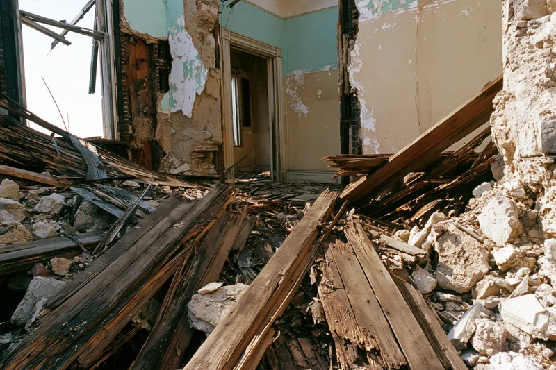 Collapsed interior of an abandoned building filled with rubble and broken wood and concrete debris