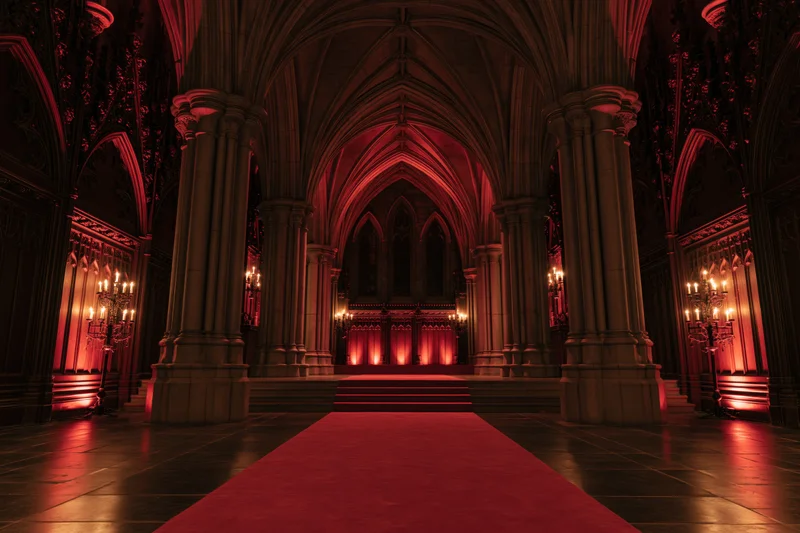Gothic hall interior with stone columns and red carpet leading to altar under candlelight
