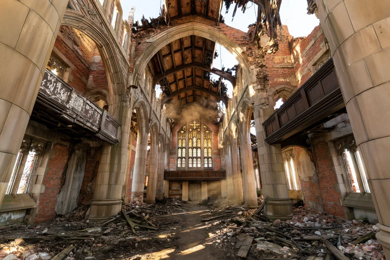 Interior of a ruined gothic church nave with collapsed ceiling and debris scattered across the floor