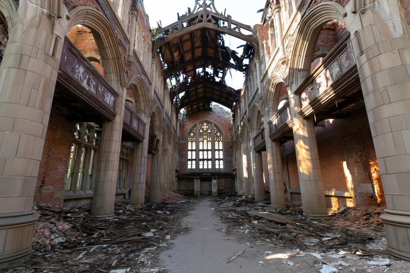 Interior of abandoned gothic church nave with collapsed roof and rubble on floor