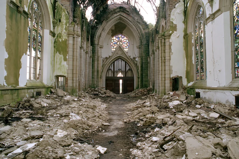 Interior of abandoned gothic church with collapsed ceiling and rubble covering the nave