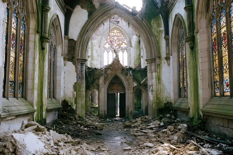 Interior of abandoned gothic church with collapsed ceiling and rubble covering the floor