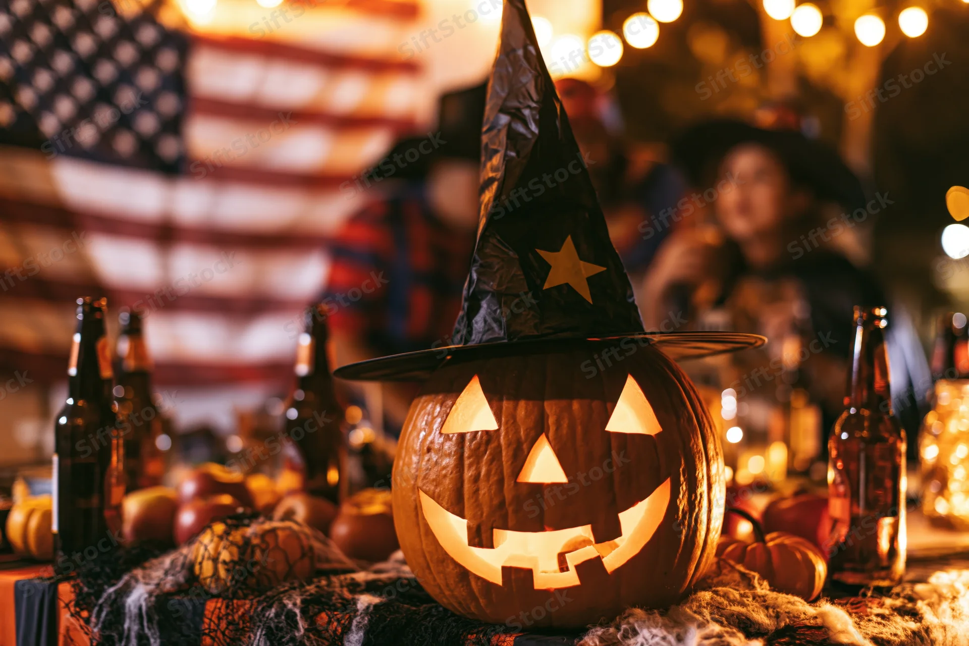 Carved pumpkin with witch hat glowing on a decorated table at a halloween party
