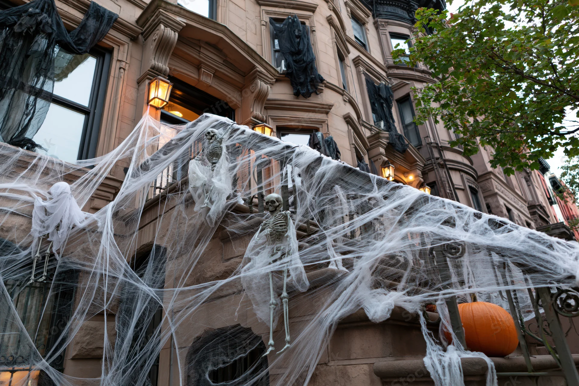 Halloween-decorated brownstone stoop with skeletons and spiderwebs in new york city