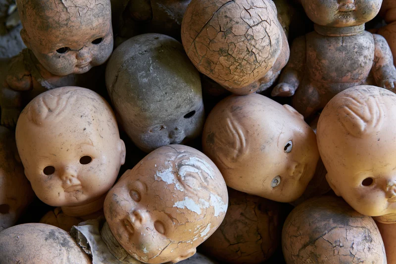 Decayed vintage baby dolls heaped together in a pile