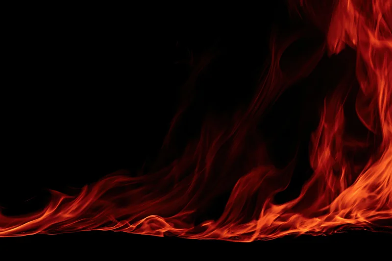 Red and orange flames curving along the bottom edge against black background
