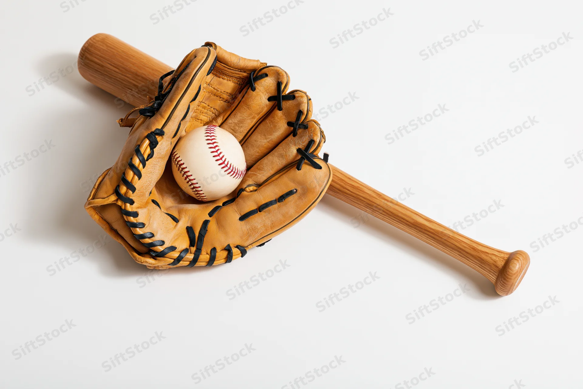 Baseball glove holding a ball with a wooden bat on white background