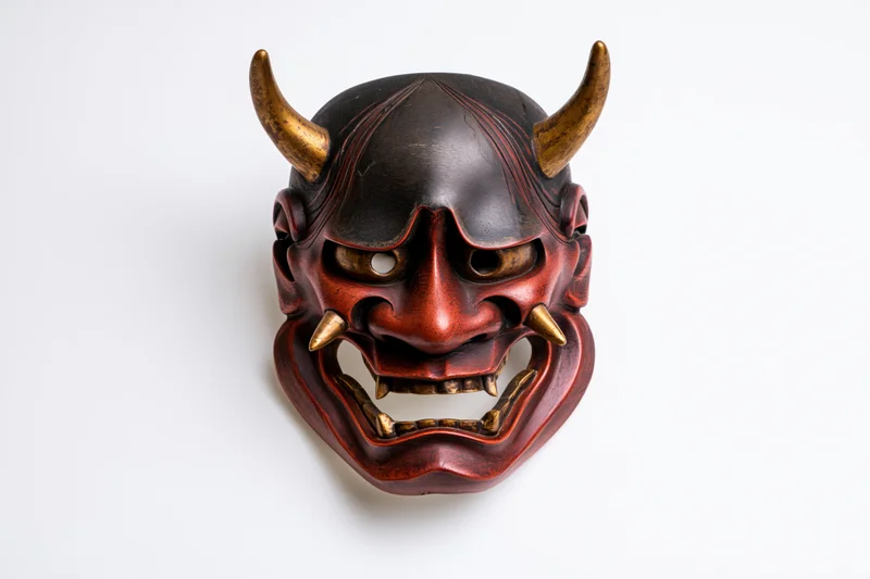 Traditional japanese hannya demon mask displayed face-forward on white background
