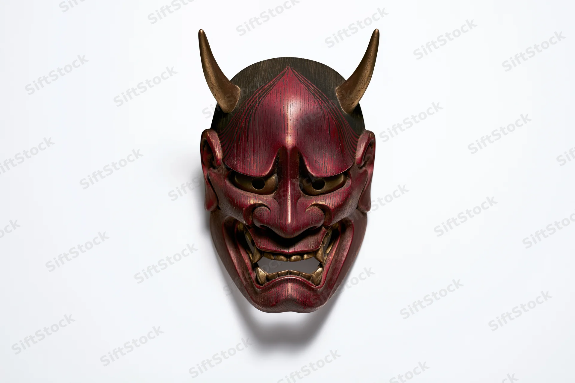 Traditional japanese hannya demon mask with horns and fanged expression displayed face-forward on white background