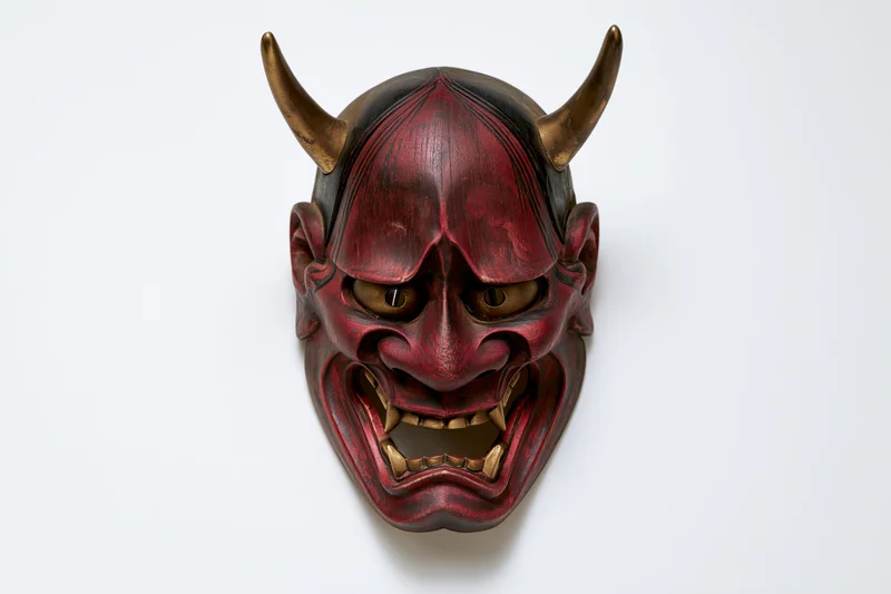 Traditional japanese hannya demon mask displayed face-forward on white background