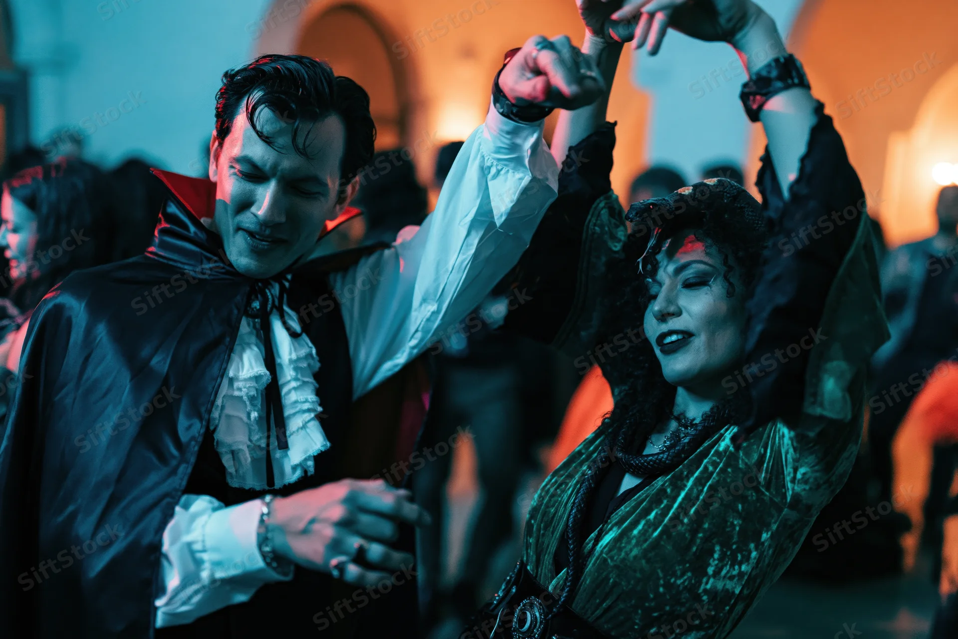 Couple in vampire costumes dancing at a halloween party