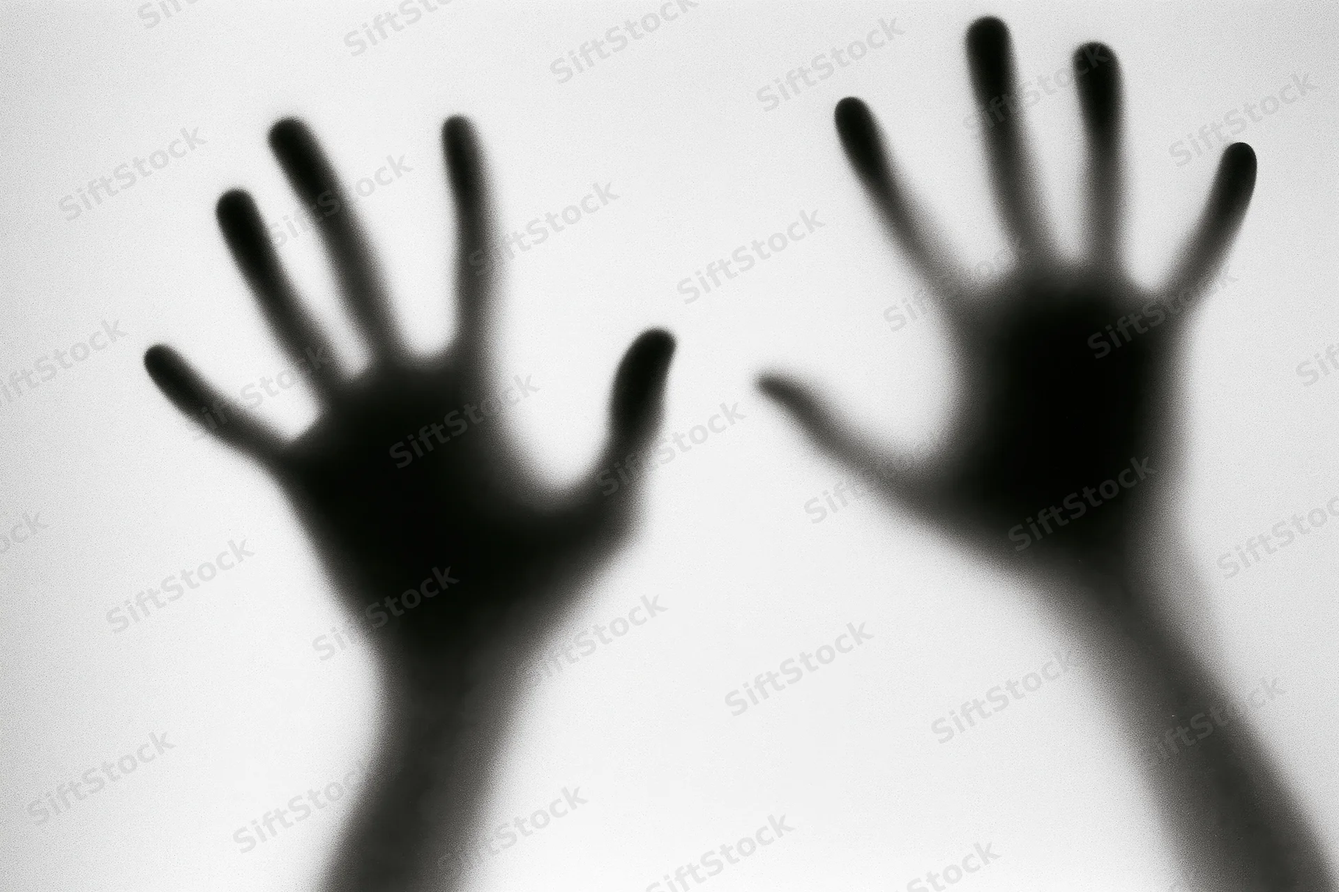 Blurred hands pressed against frosted glass in a monochrome silhouette