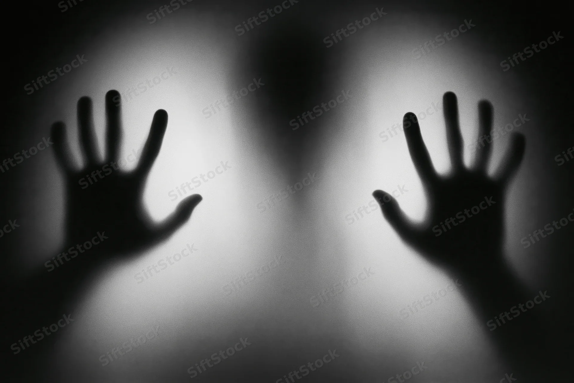 Shadowy hands pressed against frosted glass in a dark interior