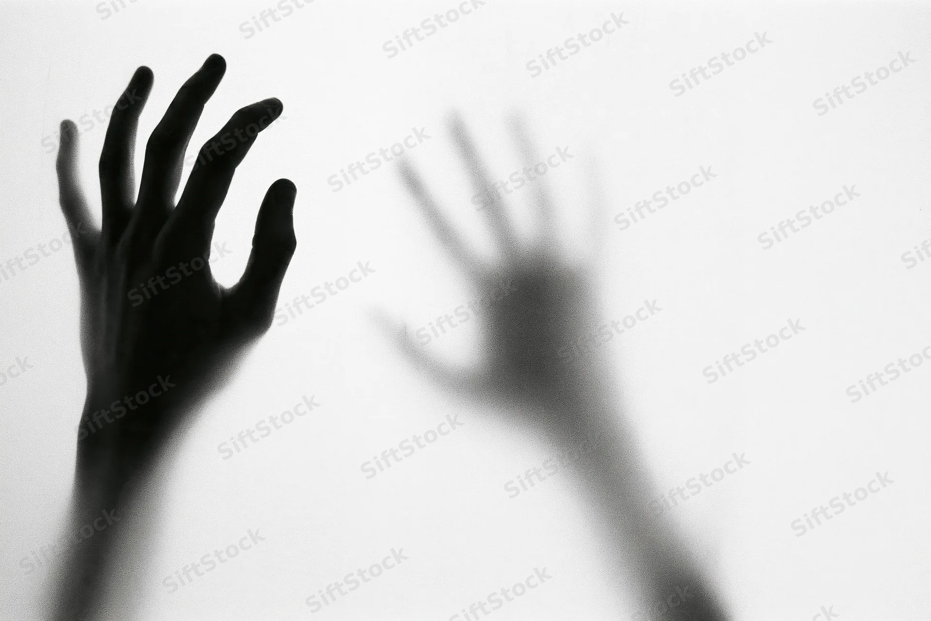 Hands pressing against translucent glass with one in sharp focus and the other blurred in reflection
