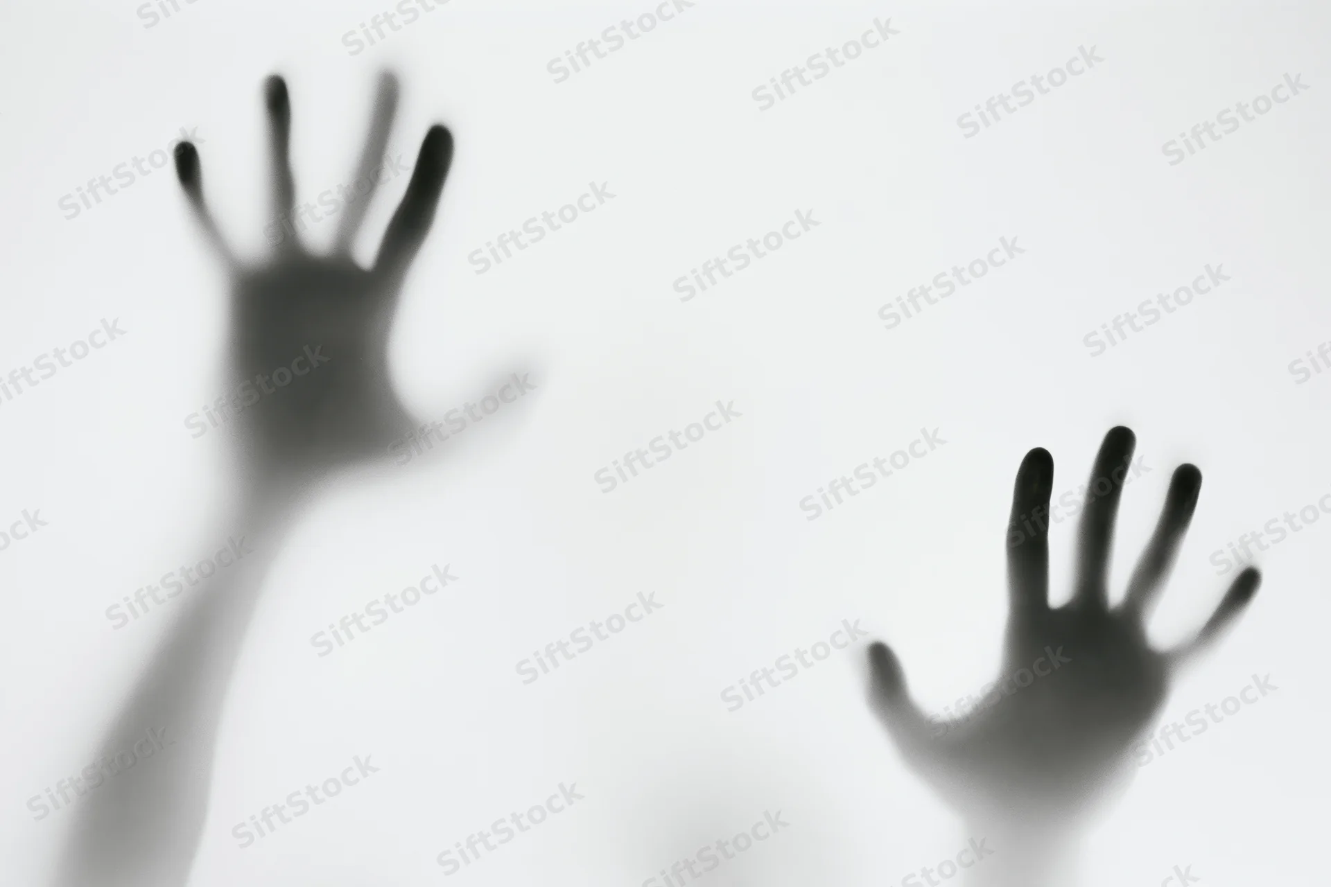 Two hands pressing against a frosted glass surface