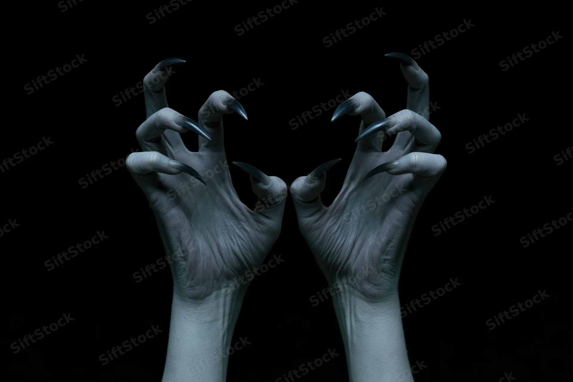 Pale hands with sharp claws extended against black background