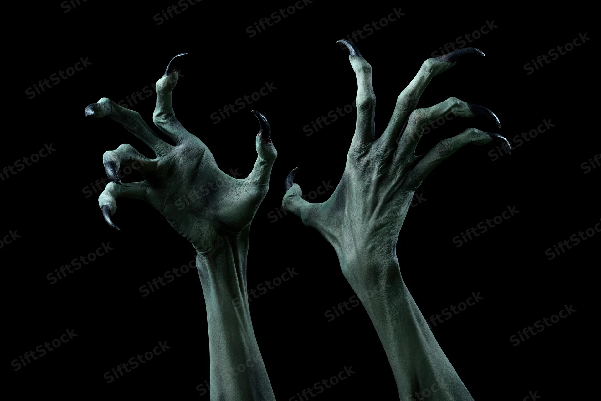 Two pale green monster hands with sharp claws reaching upward against black background