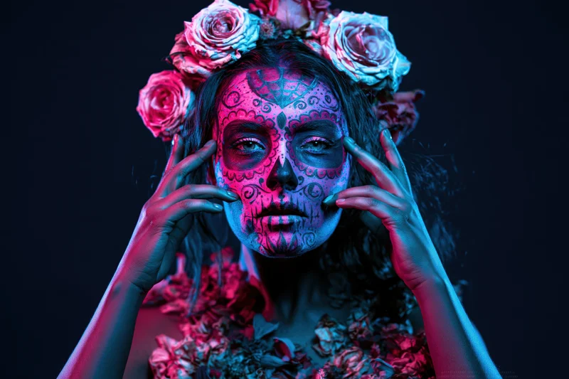 Woman with sugar skull makeup and floral crown touching her face in studio lighting